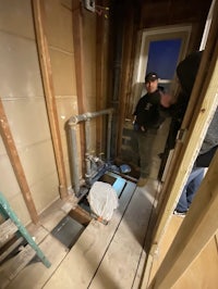 two men standing in a room that is under construction