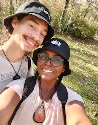 a man and woman taking a selfie in the woods