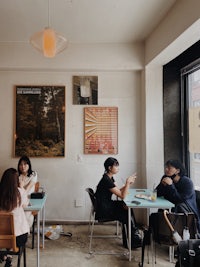 a group of people sitting at tables in a cafe