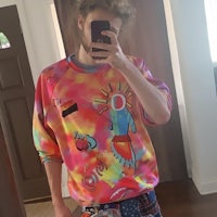 a man taking a selfie in a tie dye sweatshirt