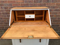 a white and wooden desk with a drawer open