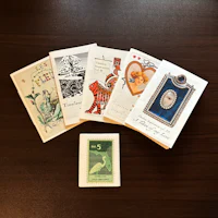 a collection of greeting cards and a stamp on a table