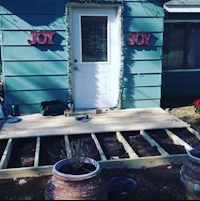 a house with a wooden deck and potted plants
