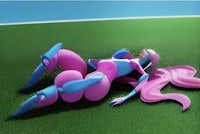 a pink and blue character laying on the grass