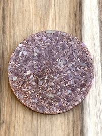 a round purple stone coaster on top of a wooden table