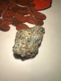 a piece of marijuana sitting on top of a white surface