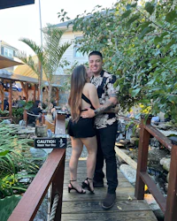 a couple embracing on a wooden bridge near a pond