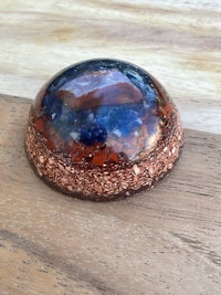 a blue and copper sphere on top of a wooden table