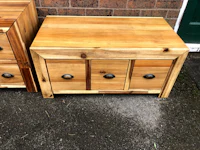 two wooden nightstands with drawers in front of a brick wall
