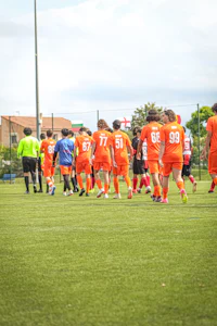 a group of soccer players walking on a field