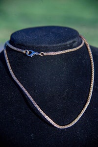 a gold chain with a clasp on a mannequin