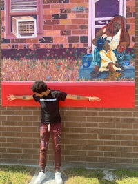 a man standing in front of a mural