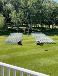 a wedding ceremony set up on a grassy field