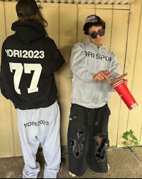 two people standing next to each other holding a cup