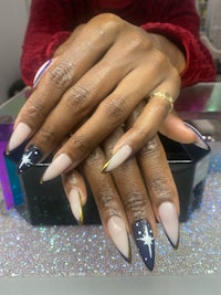a woman's hands with black and gold nails