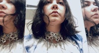 a woman wearing a choker in a mirror