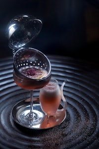 a cocktail is sitting on top of a silver plate
