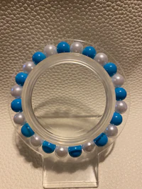 a clear ring with blue and white beads on it