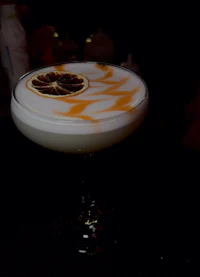 a cocktail with a lemon slice on top