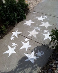 a sidewalk with white stars painted on it