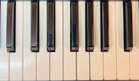 a close up of a piano keyboard with black and white keys