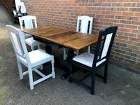 four chairs and a table in front of a brick wall