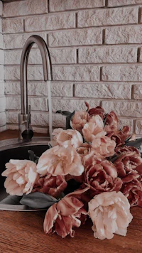 a kitchen sink with flowers in it