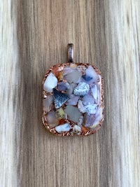 a pendant with a white and brown stone on it