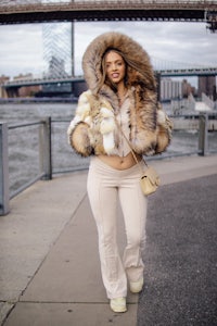 a woman wearing a fur jacket and pants