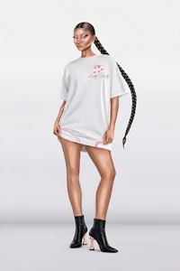 a woman wearing a white t - shirt and black boots