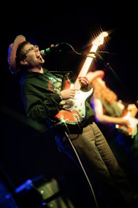 a man playing a guitar in front of a microphone