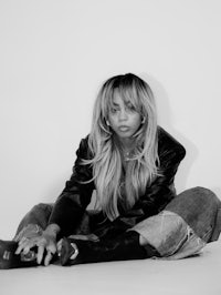 a black and white photo of a woman sitting on the floor