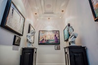 a hallway with statues and paintings on the wall
