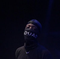 a man wearing a black mask with the word duad on it