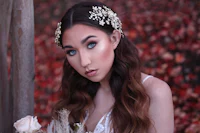 a bride in a white dress with flowers in her hair