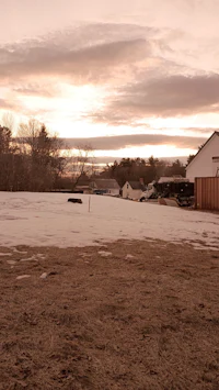 a snow covered field with a house in the background