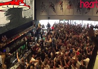 a crowd of people at a bar watching a movie