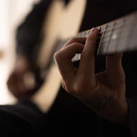 a close up of a person playing an acoustic guitar