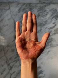 a person's hand with red paint on it