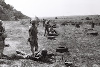a group of soldiers standing in a field with guns