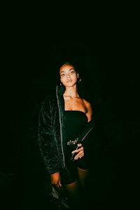 a woman in a black dress posing at night