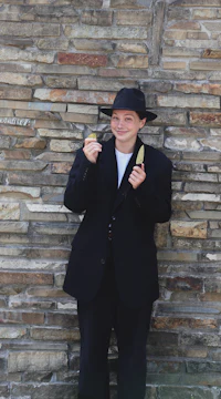 a man in a black hat holding a pair of chopsticks