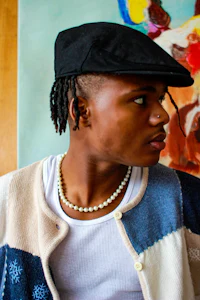 a young man wearing a hat and a sweater