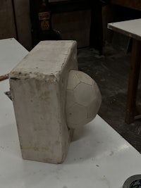 a soccer ball is sitting on top of a concrete block