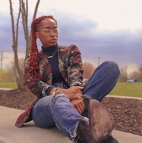 a woman wearing a jacket and jeans