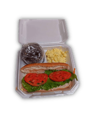 a sandwich with tomatoes and eggs in a white box