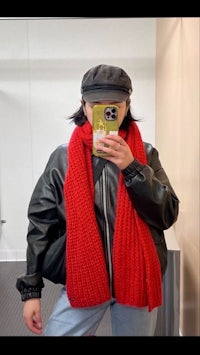 a woman is taking a selfie in a mirror wearing a red scarf
