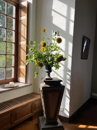 a vase of flowers in a room with a window