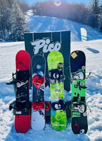 a group of snowboards sitting on a chair in the snow