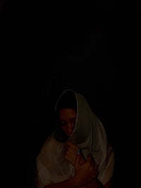 a woman wearing a white shawl in the dark